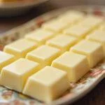 Barras de chocolate blanco sin azucar casero perfectamente presentadas, listas para disfrutar.