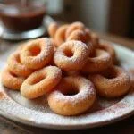 Delicious freshly made churro porras dusted with sugar and cinnamon, served with chocolate sauce for dipping.